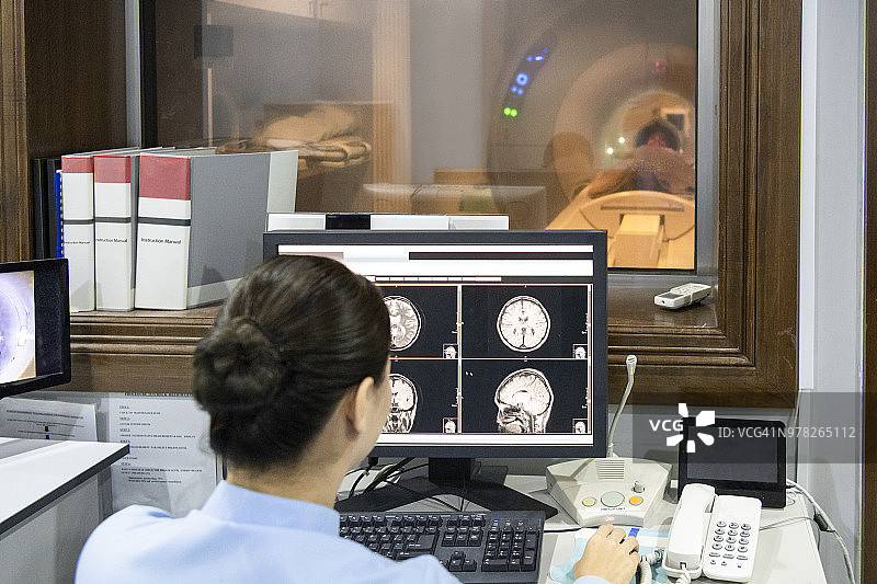 放射技师查看电脑屏幕上的MRI扫描图像图片素材