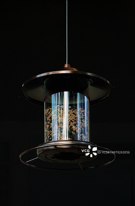 装满种子的悬挂式喂鸟器特写图片素材