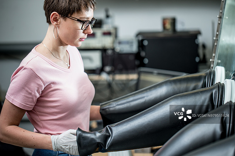 年轻女研究员使用手套箱测量有机半导体中的瞬态光电流图片素材