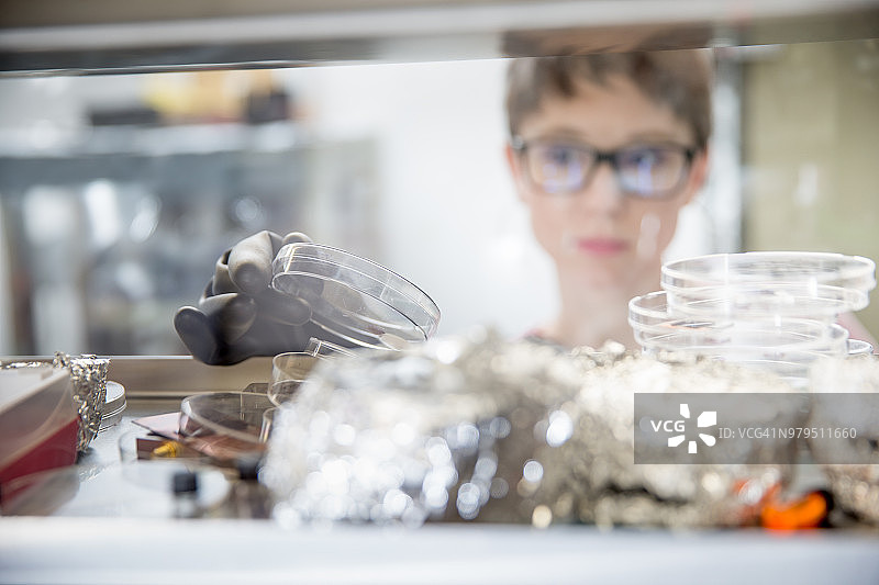 年轻女研究员在手套箱中准备样品，用于测量有机半导体中的瞬态光电流图片素材