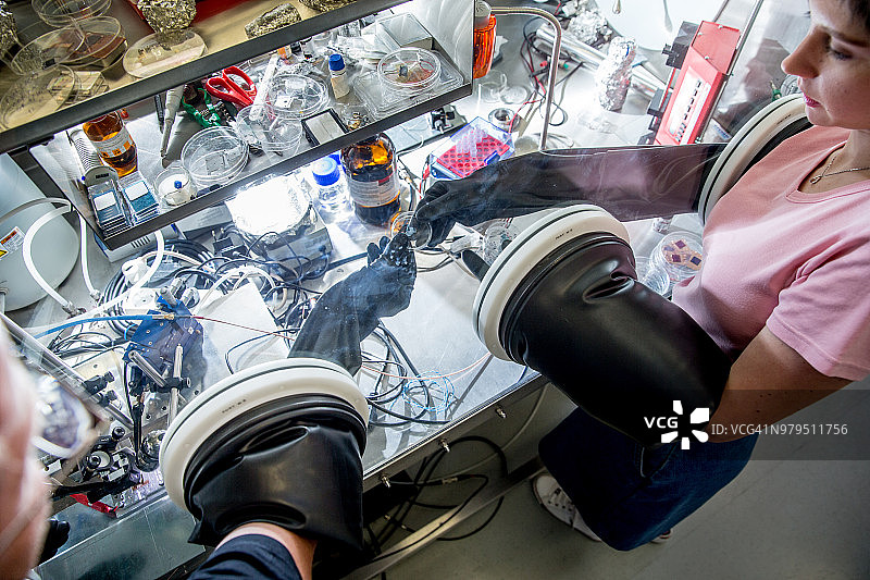 研究人员在手套箱中准备样品，以测量有机半导体中的瞬态光电流图片素材