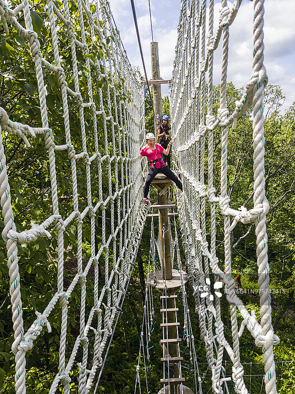 成年女性正在通过滑索。手机拍摄图片素材