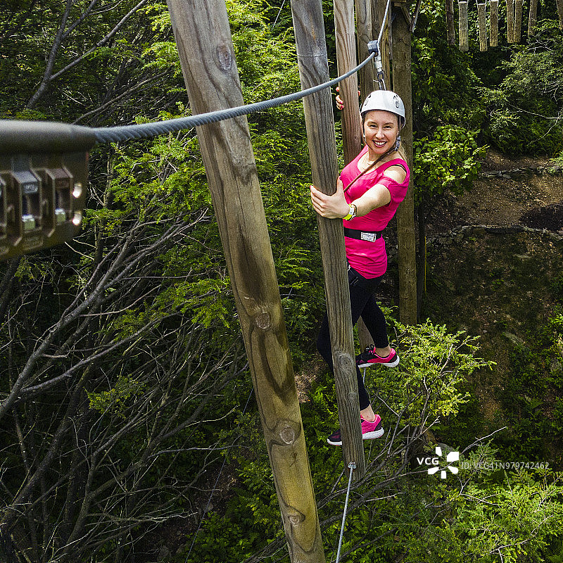 成年女性正在通过滑索。手机拍摄图片素材