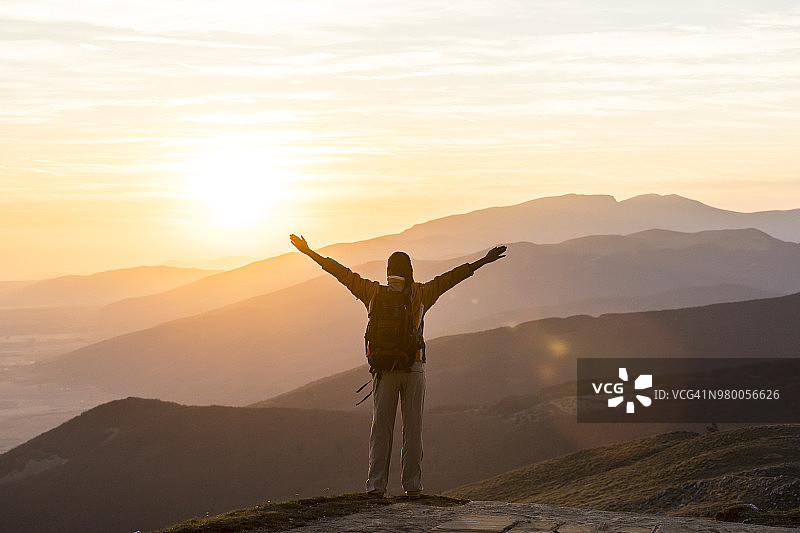 开心的徒步者在山顶伸展双臂图片素材