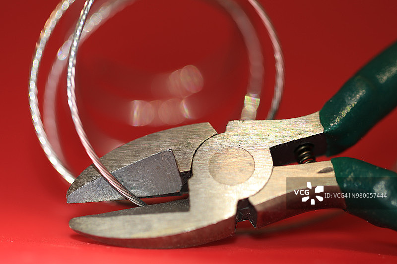 红色背景上的钢丝钳和相框悬挂线图片素材