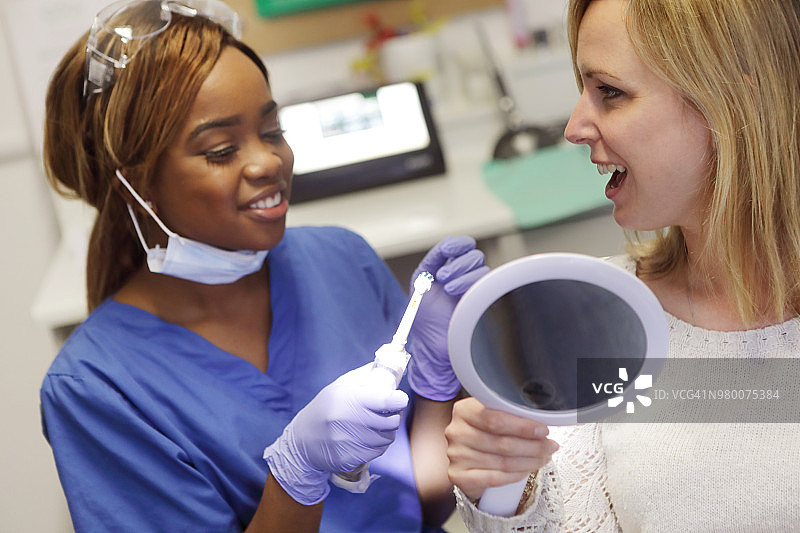 牙医与患者讨论电动牙刷图片素材