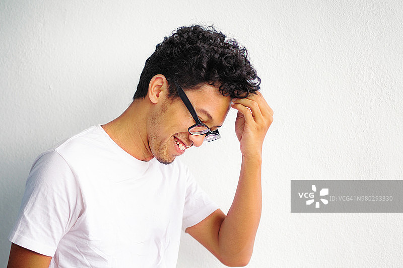 年轻的亚洲害羞的知识分子男人微笑并触摸他的头部图片素材