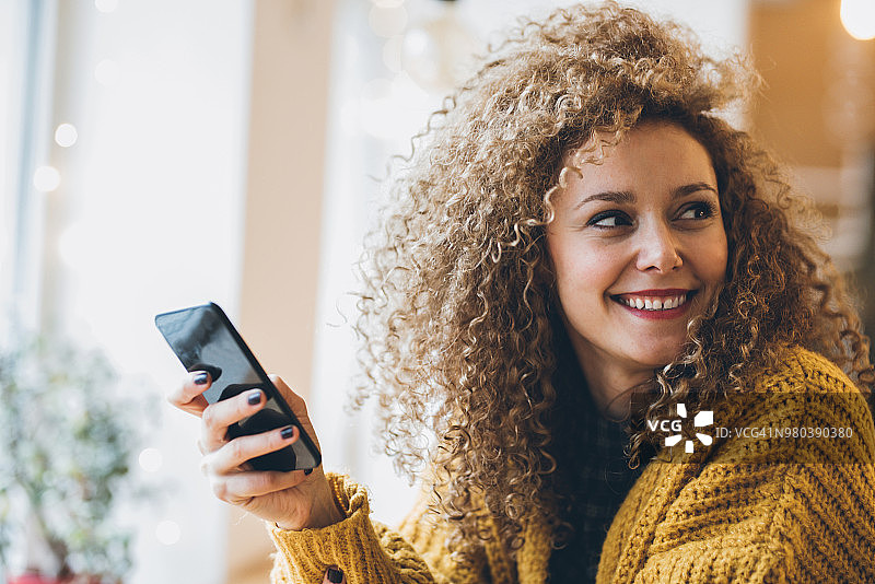 漂亮的女人在手机上发短信图片素材
