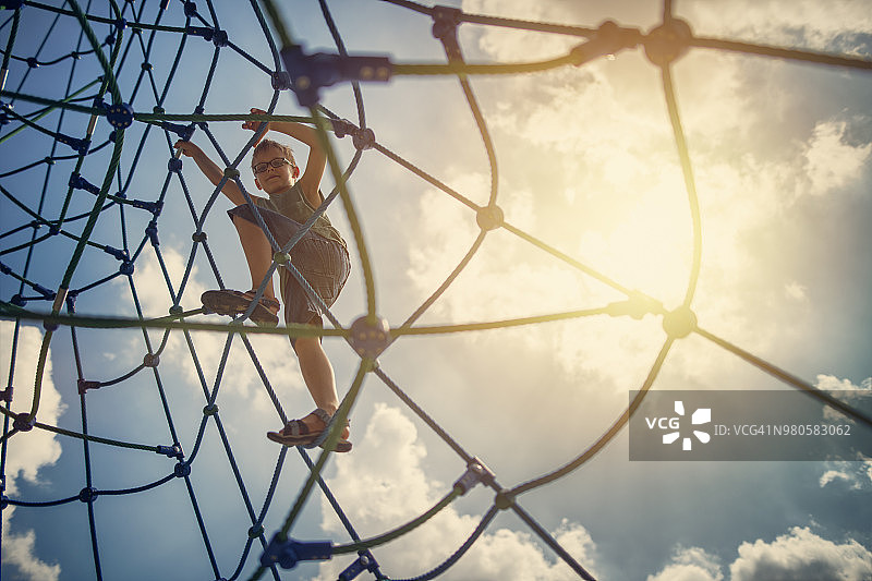 小男孩在操场上攀爬图片素材
