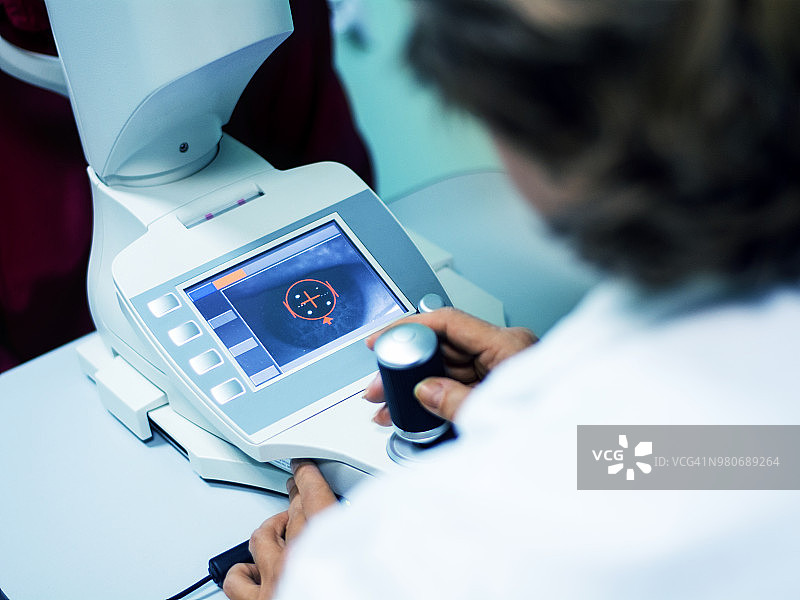 眼科角膜地形图显示眼睛和荧幕上的角膜图片素材