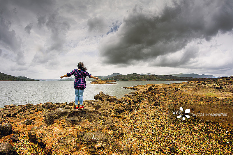 一位年轻的成年女孩在孟买附近的帕瓦纳湖享受自由的感觉图片素材