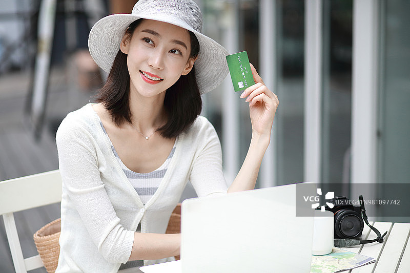 女人在咖啡馆用信用卡在网上购物图片素材