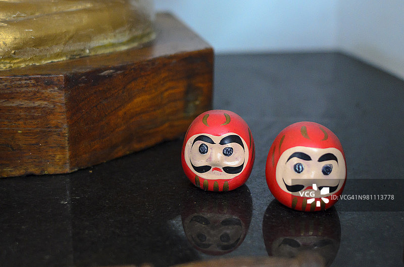 达摩：一种没有四肢的圆形日本玩偶，有着宽阔的眼睑，通常由木头制成，涂成红色、黑色和金色，描绘了菩提达摩僧侣（2018年6月拍摄）图片素材