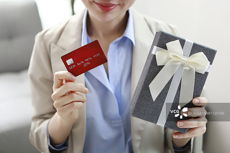手持礼品盒和信用卡的商务女性图片素材