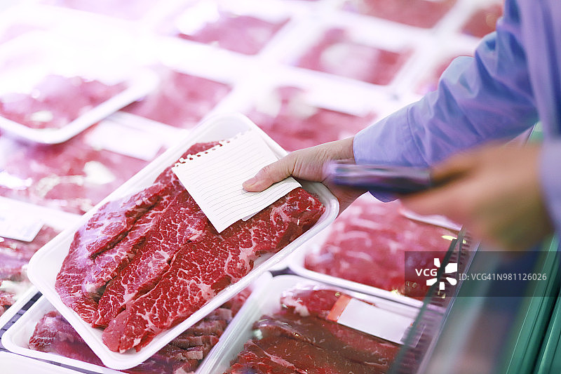在超市挑选牛肉的女人图片素材