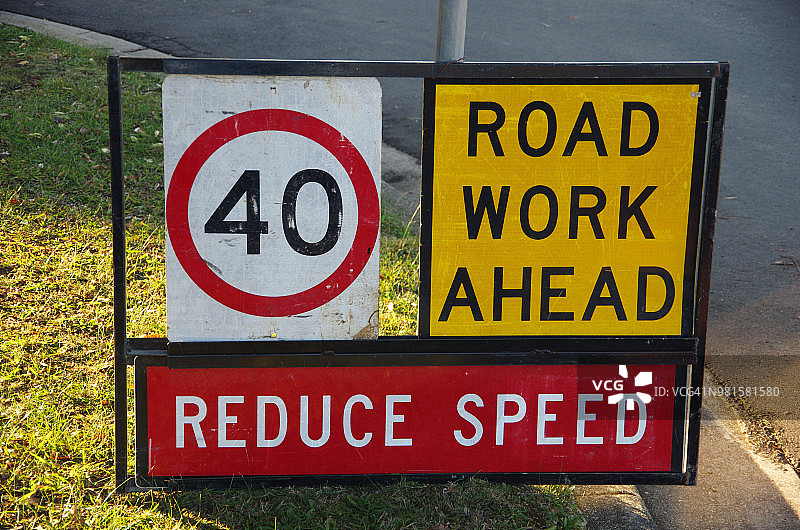 郊区道路上的‘前方施工’、‘减速’和时速40公里限速标志图片素材