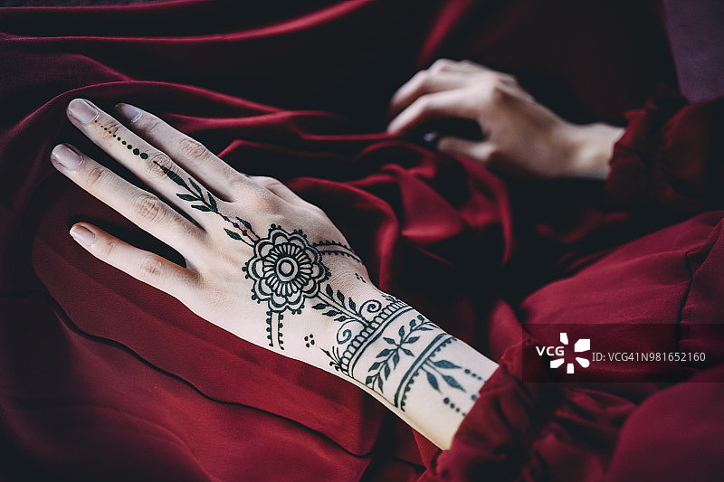红布上带有海娜纹身的女人手图片素材