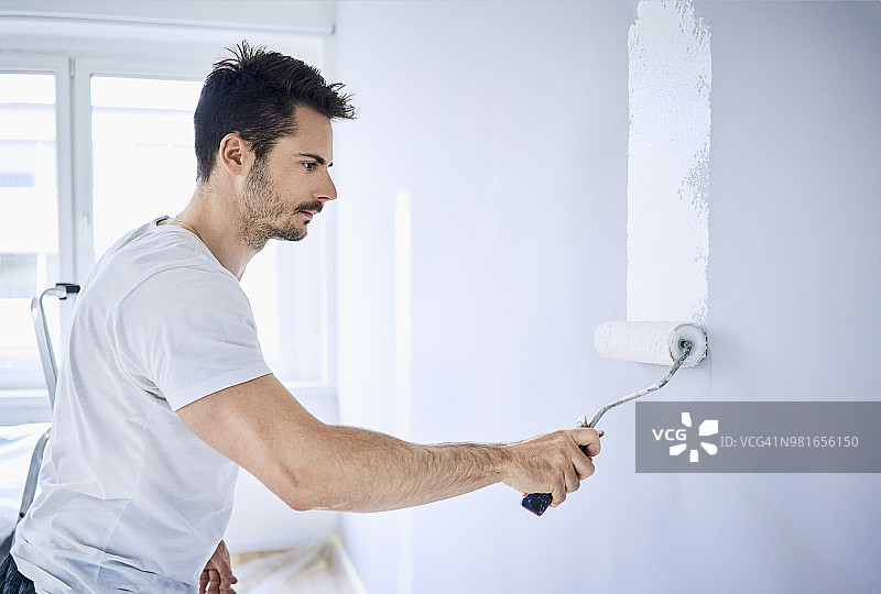 男人在公寓里粉刷墙壁图片素材