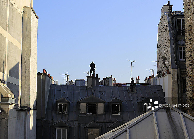 巴黎：站在烟囱顶端的男子剪影图片素材