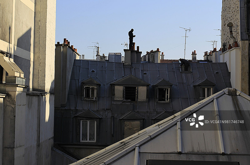 巴黎：站在烟囱顶端的男子剪影图片素材