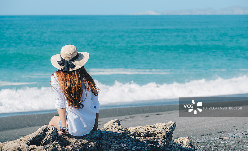 新西兰内皮尔：亚洲女性黑沙滩旅行背影图片素材
