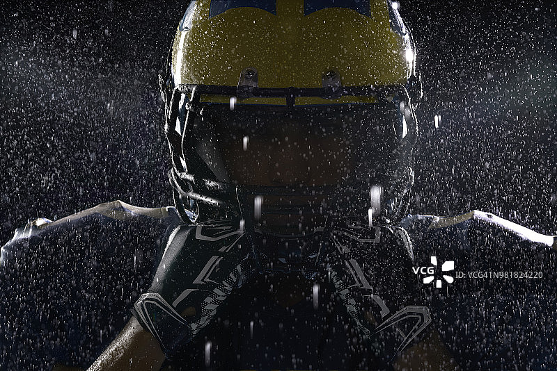 黑色背景下，烟雾和雨中的美式橄榄球运动员特写肖像图片素材