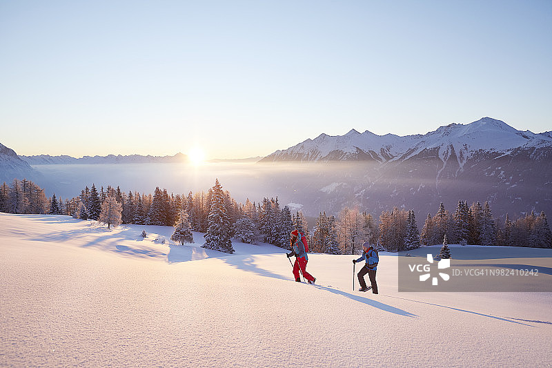 奥地利蒂罗尔州日出时分的雪鞋徒步者图片素材