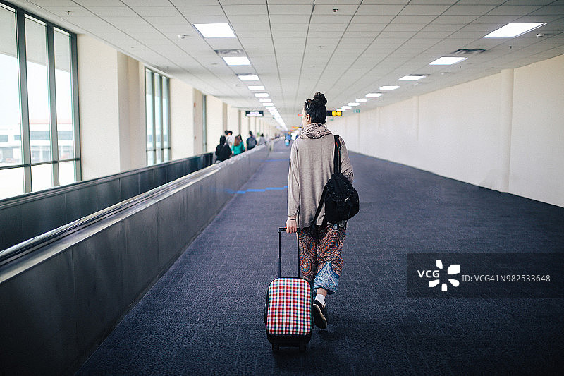 在泰国甲米机场独自旅行，手提行李箱的年轻女人图片素材