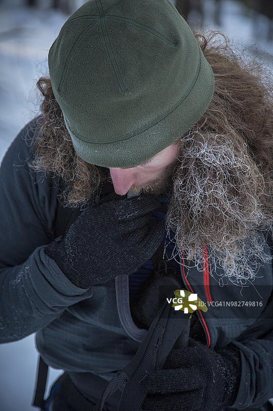 头发结霜的男人在野外滑雪时喝水图片素材