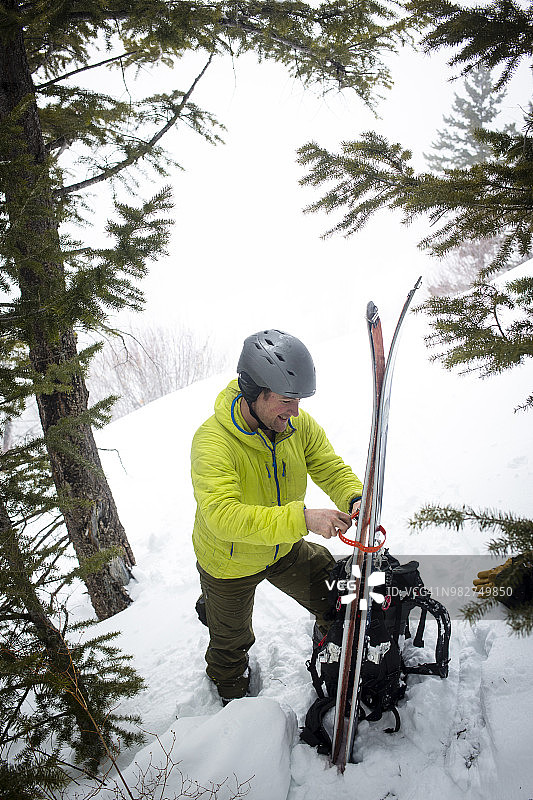 偏远地区的滑雪者将滑雪板绑在背包上图片素材