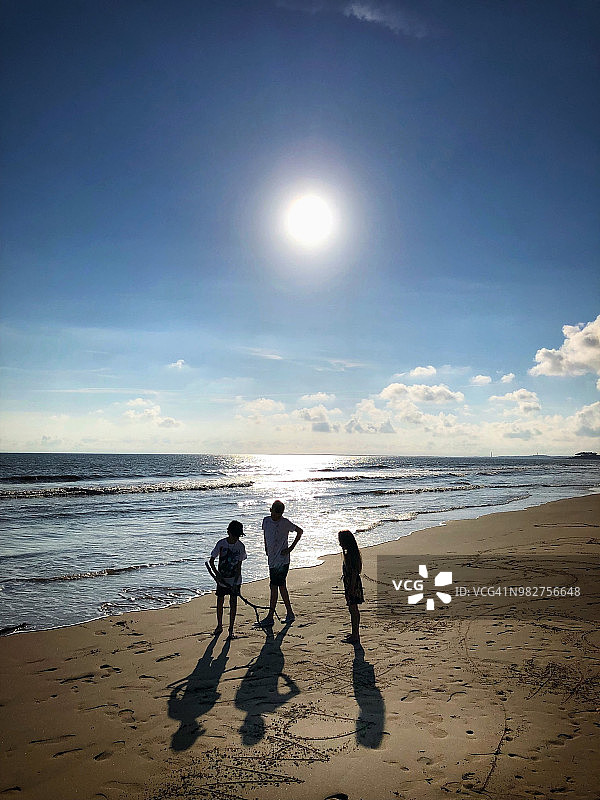 法国鲁扬海滩上三个孩子的轮廓图片素材