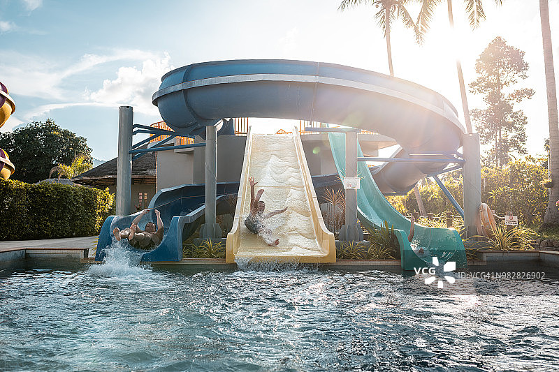 朋友们在水上乐园的滑梯上玩耍图片素材