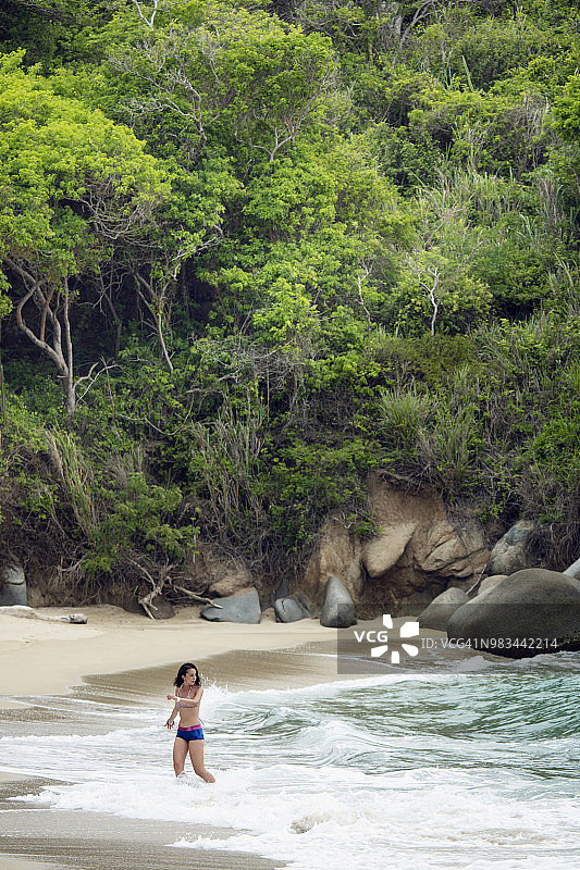 年轻女子身穿比基尼在哥伦比亚的热带海滩上享受大自然图片素材