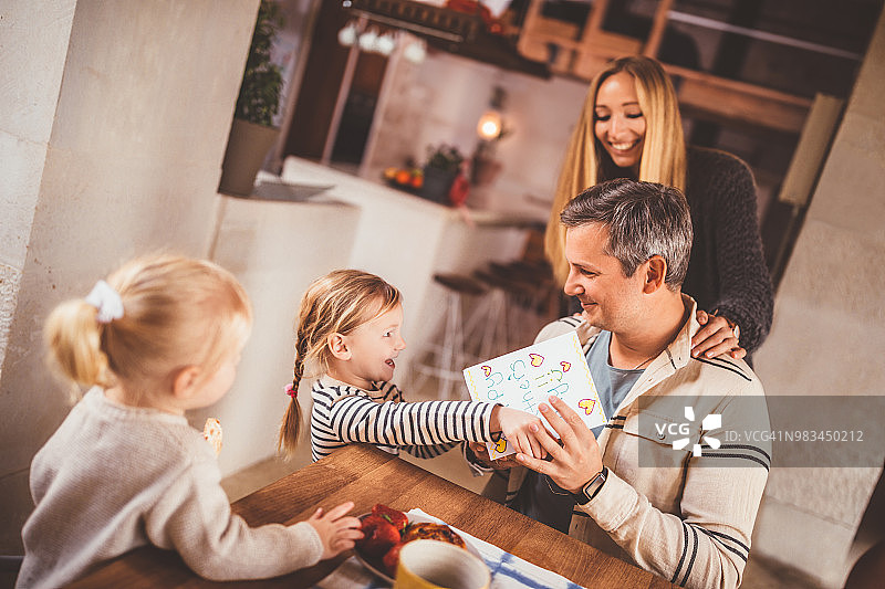 快乐的小孩子们在父亲节送给父亲贺卡图片素材