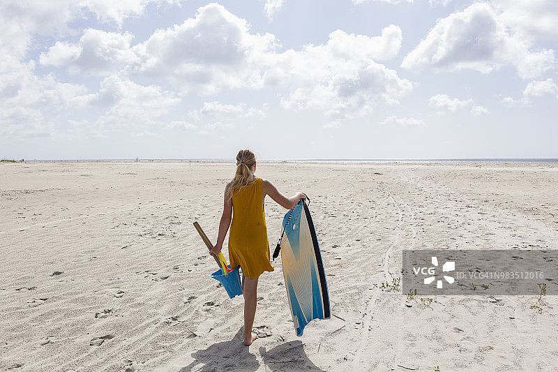 走向海滩的女孩的后视图图片素材