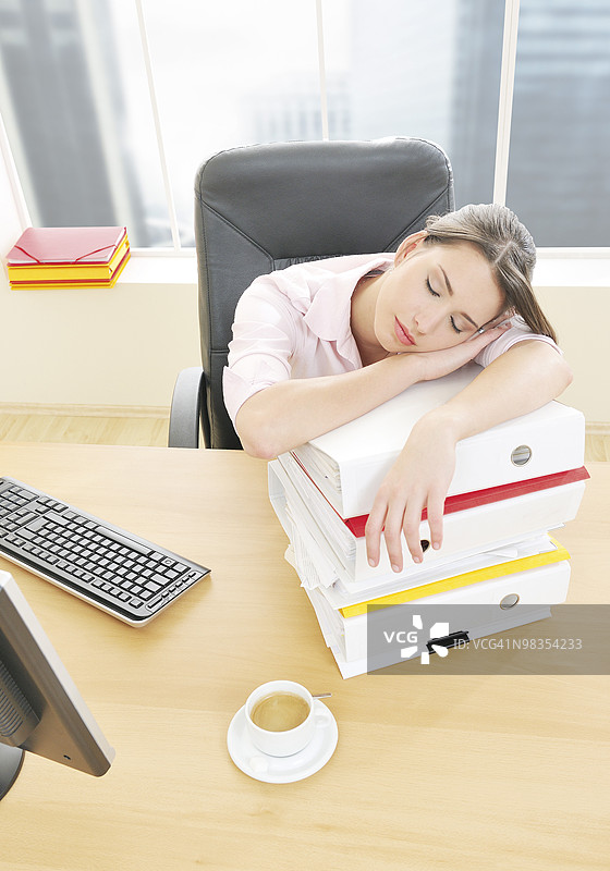 女人在办公室的文件夹上睡觉图片素材