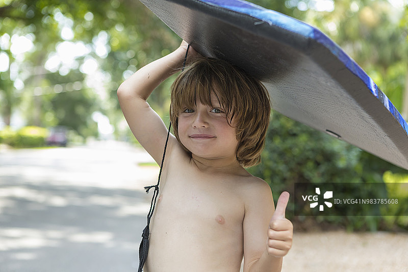 举着趴板的4岁男孩图片素材