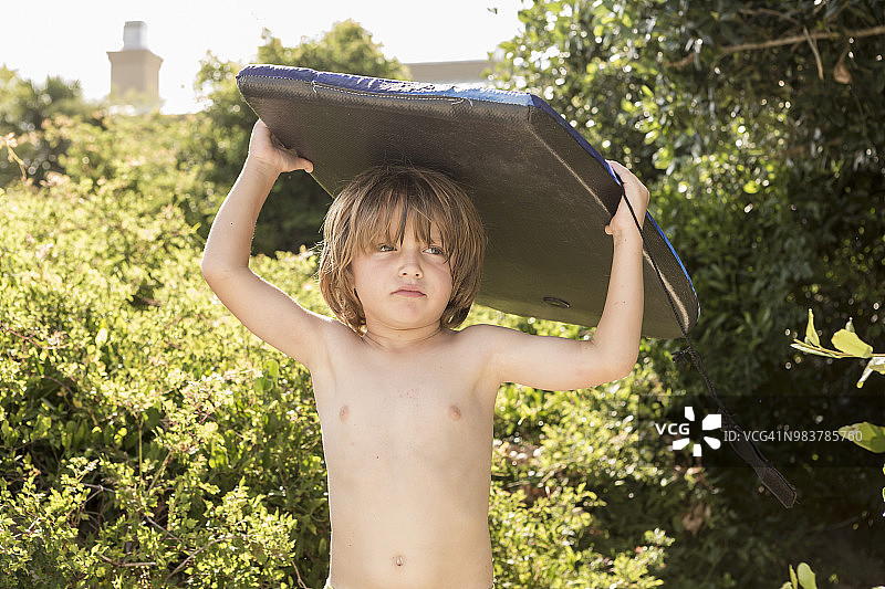 举着趴板的4岁男孩图片素材