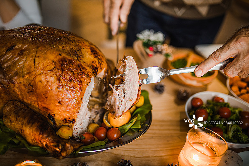 雕刻感恩节烤火鸡的男子特写图片素材
