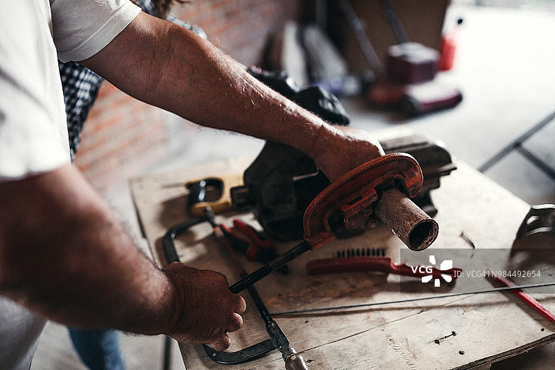 男人使用割管器切割管道图片素材
