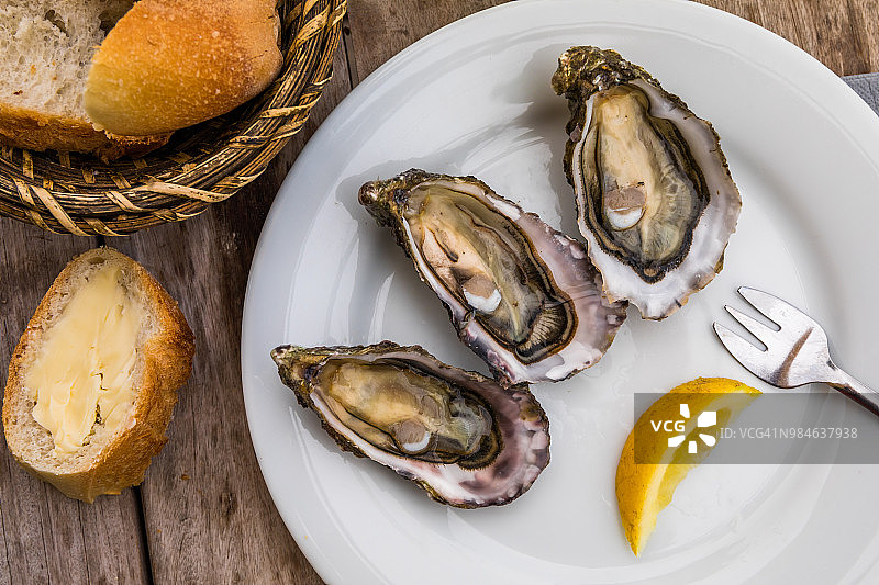 鲜蚝配柠檬、面包和黄油图片素材