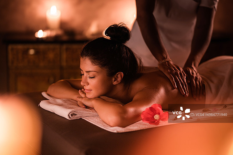 年轻女人在水疗中心享受放松按摩图片素材