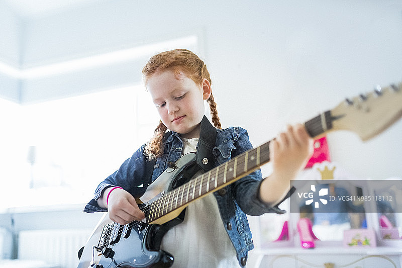 女孩在家中房间弹电吉他图片素材