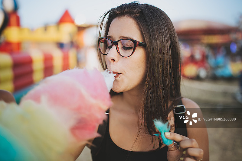 女孩在乡村集市吃棉花糖图片素材