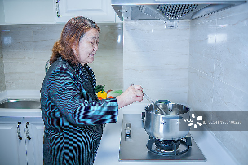 年长妇女在厨房做饭图片素材