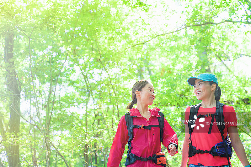 两名女性徒步旅行者绕着山走图片素材