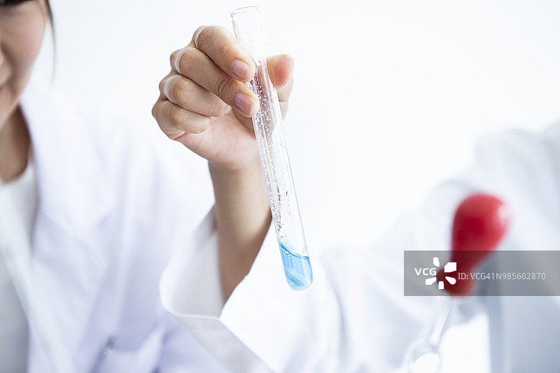 观察试管内液体的女人图片素材