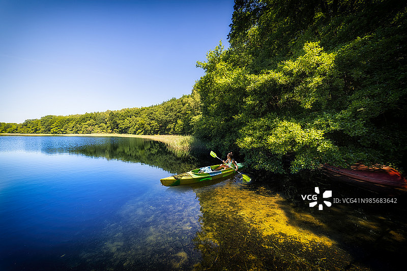 波兰度假：女子在因斯科湖上划皮划艇图片素材