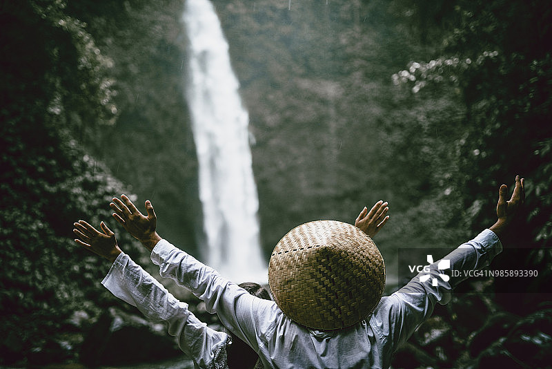 情侣欣赏瀑布附近的自然风光图片素材