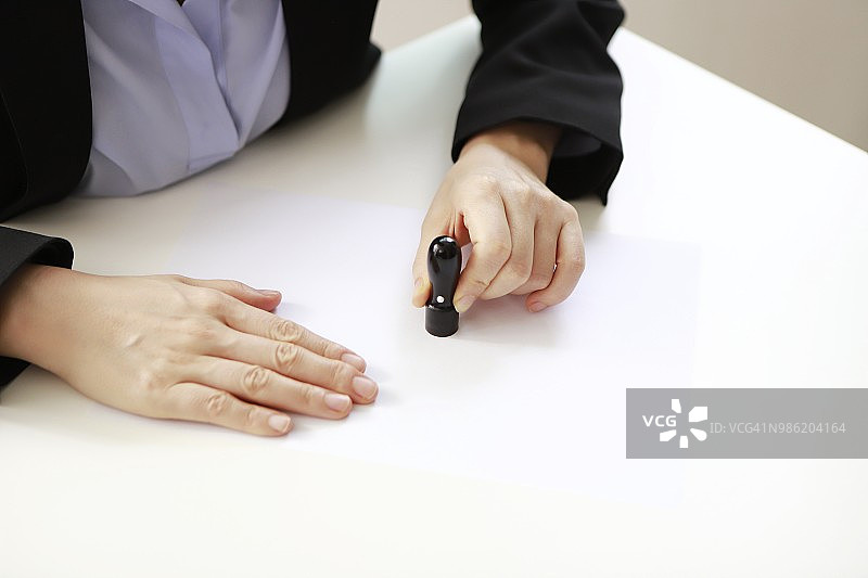 女商人在纸上盖章图片素材